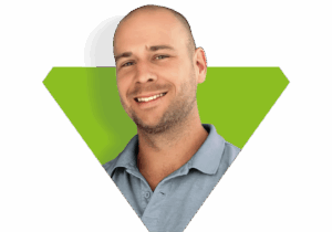 Mike Aldinger, Gründer von Aldinger Solutions, lächelt vor einem grünen V-förmigen Hintergrund